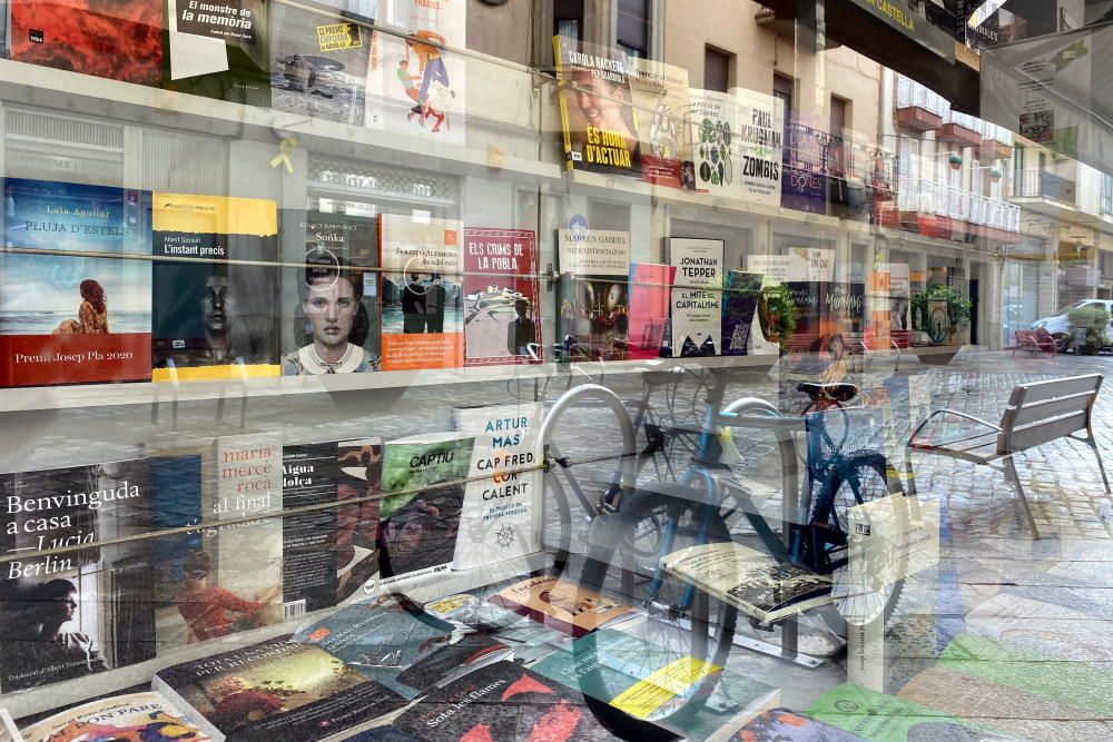 Reflexes a l'aparador de la llibreria 22 de Girona, tancada per Sant Jordi