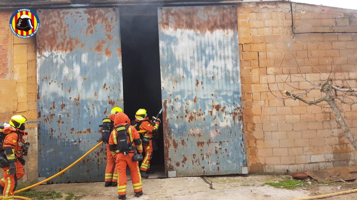 Los bomberos extinguen el fuego en la nave de Aielo de Malferit