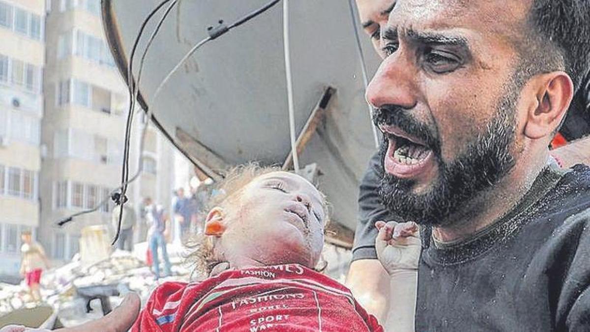 Un palestino, con su hija muerta tras un bombardeo israelí.