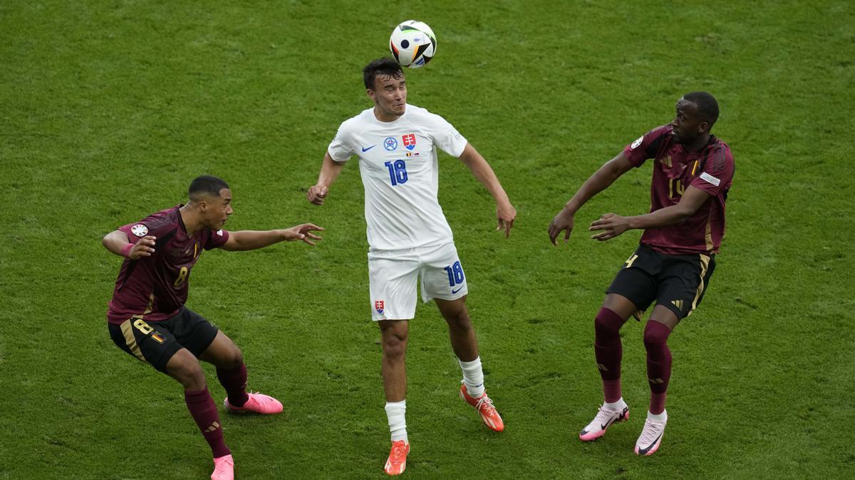 El eslovaco David Strelec, en el centro, cabecea el balón junto a los belgas Youri Tielemans, a la izquierda, y Dodi Lukebakio durante el partido del Grupo E entre Bélgica y Eslovaquia en la Eurocopa 2024 de fútbol en Frankfurt, Alemania.