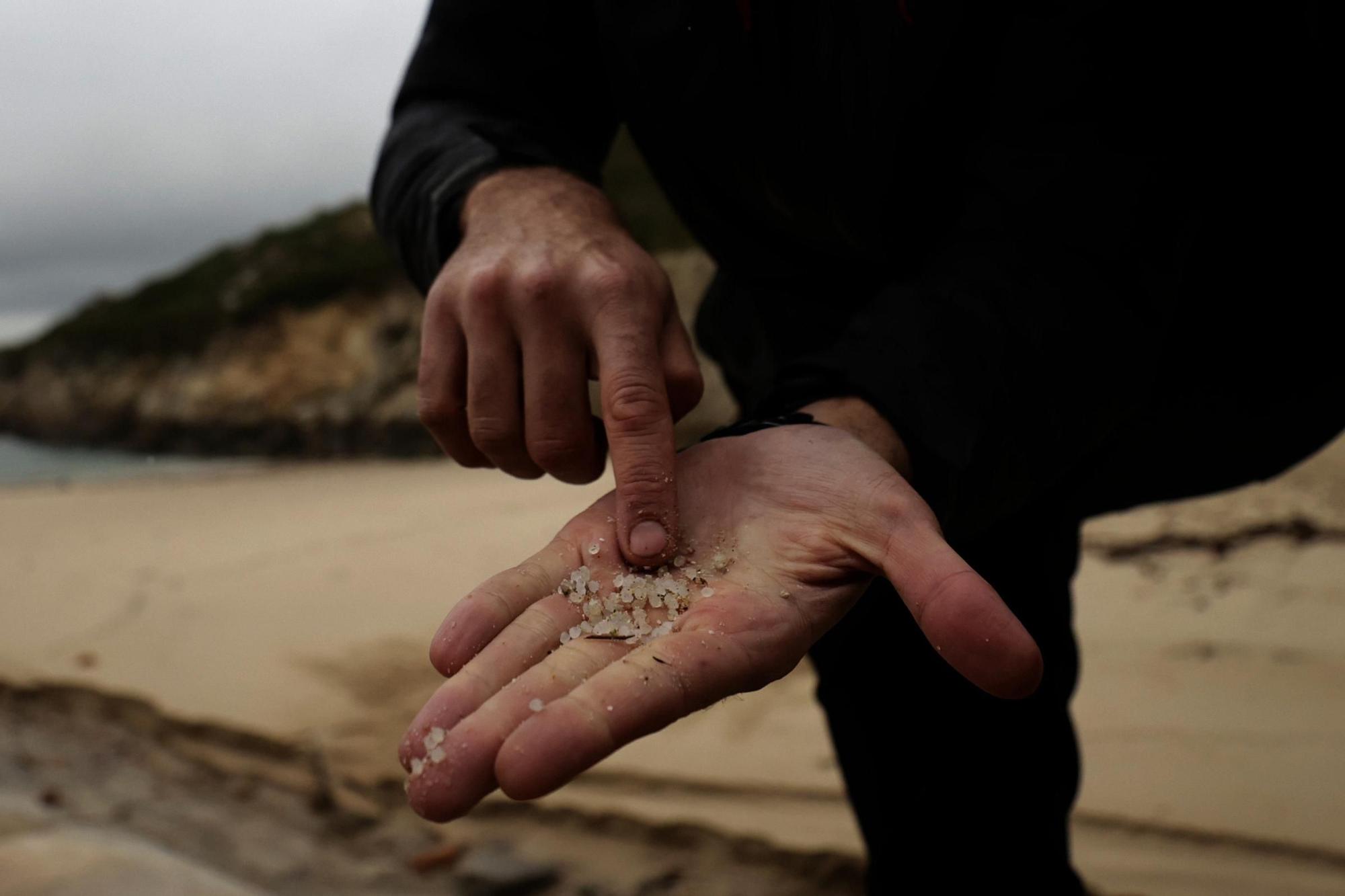 Una persona muestra pellets recogidos en la playa de As Lapas