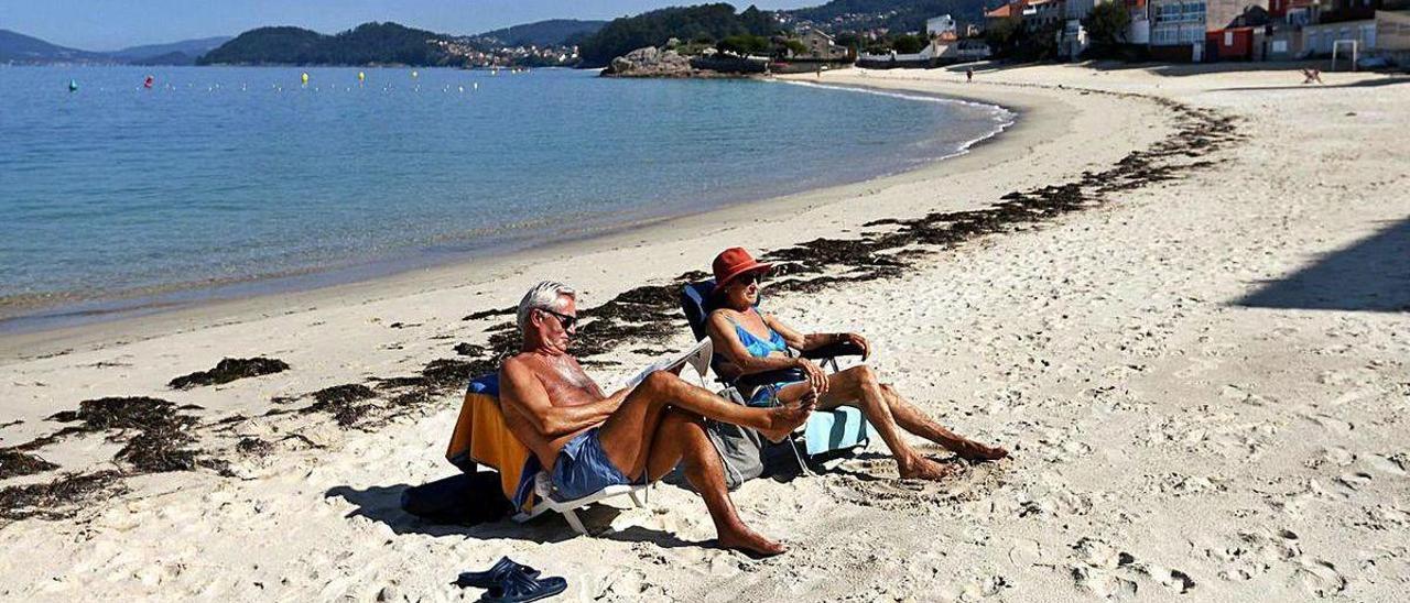 Dos personas disfrutan ayer de la playa de Loureiro, en Bueu.