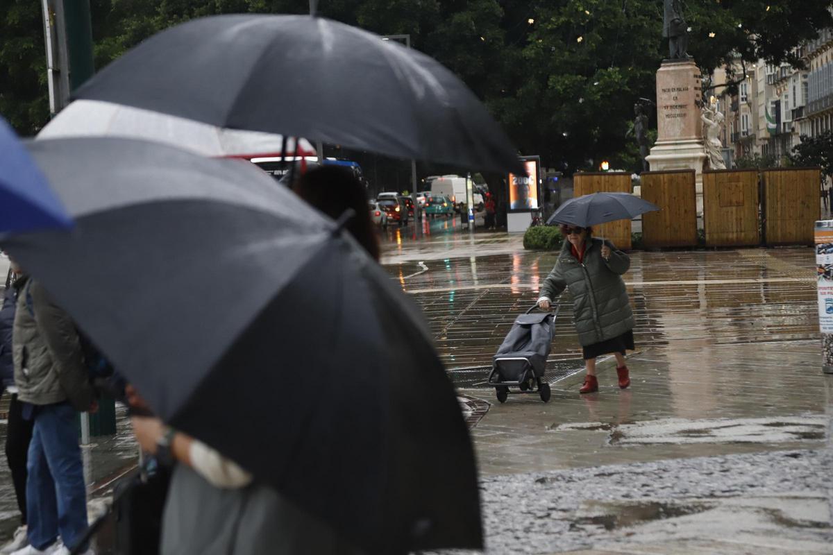 Archivo - Personas con paraguas por las calles de Málaga con lluvia en una imagen de archivo