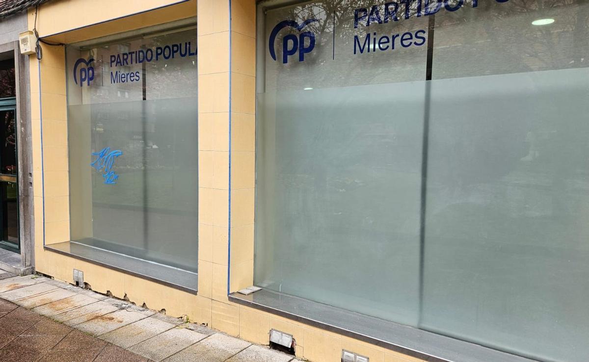 La sede del PP de Mieres, con la pintada a en la luna de la izquierda de la imagen. | FOTO CEDIDA A LNE