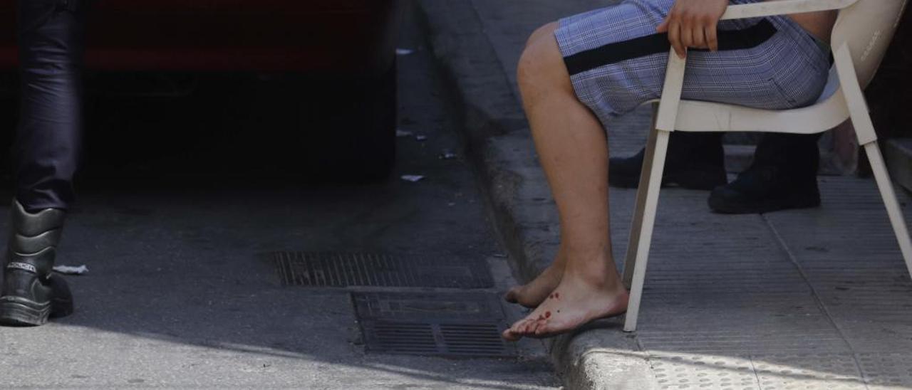 El hijo de una de las mujeres heridas en el tiroteo, el jueves, todavía con restos de sangre en los pies.