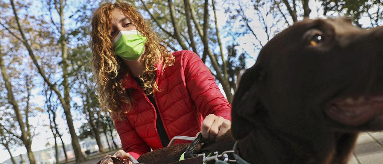 Raquel González, con su perra “India” en el parque del Muelle.   | RICARDO SOLÍS