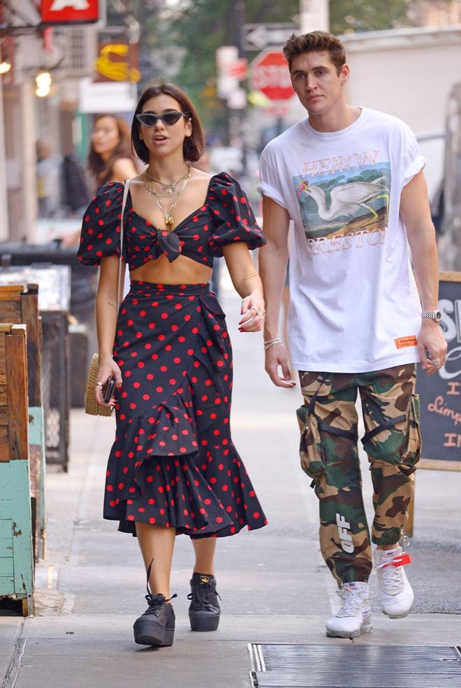 Dua Lipa pasea con su novio por NY con un conjunto de top + falda de lunares rojos