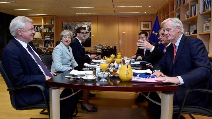 Davis y la &quot;premier&quot;, Theresa May (a su izq.), sentados frente al negociador de la Ue, Michel Barnier, y el presidente de la Comisión Europea, Jean-Claude Juncker, negociando el viernes en Bruselas. // Reuters