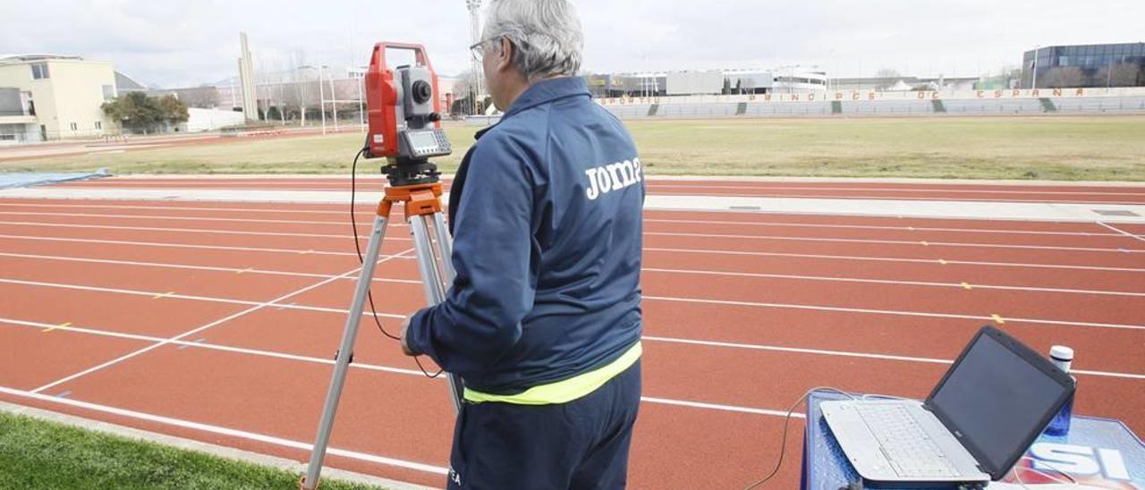Un técnico de la Española de Atletismo somete a la pista a mediciones para su homologación.
