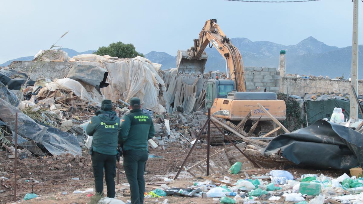 Dos agentes de Guardia Civil asisten al desalojo y derribo del asentamiento chabolista de El Walili en Níjar (Almería).