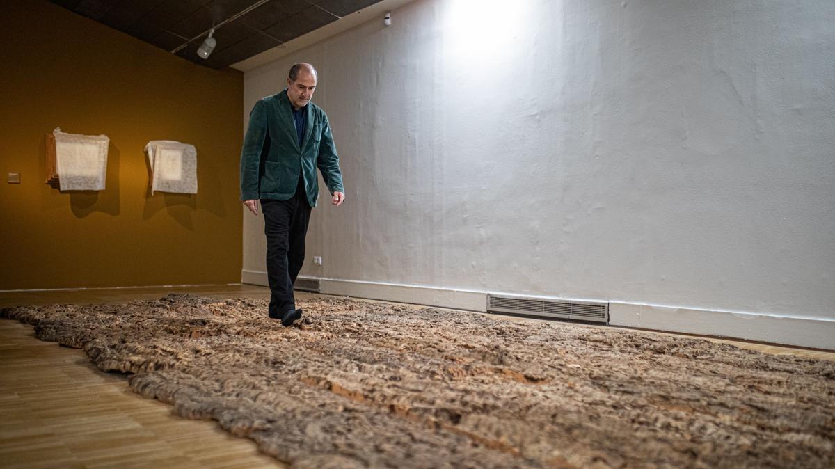 El comisario Carles Guerra, caminando sobre la alfombra de corcho, obra de Perejaume.