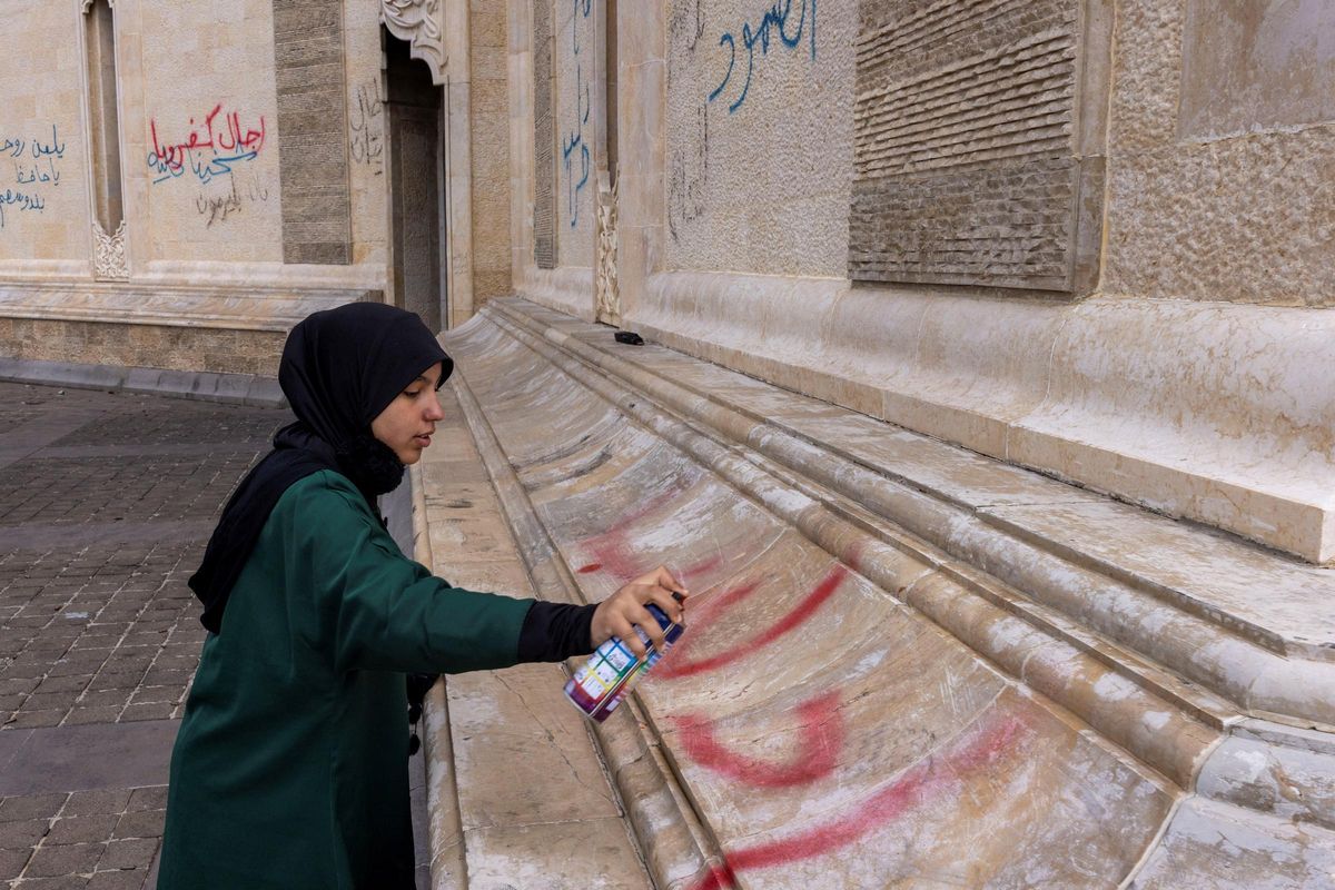 Una chica escribe "Idlib", en nombre de la ciudad norteña siria, en las paredes de la tumba de Hafez el Asad, padre de Bashar, en Qardahah.