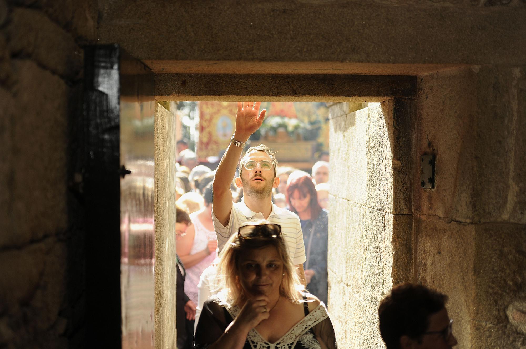 Un hombre toca el dintel de la puerta santa.