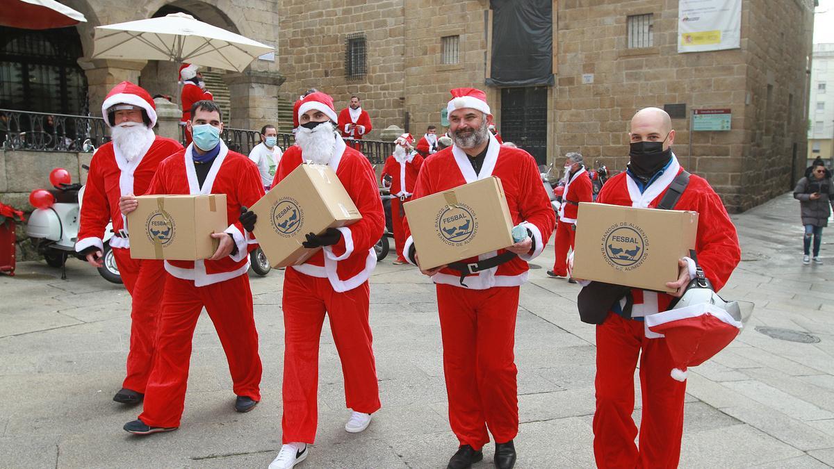 Varios papanoeles portan las cajas recogidas en uno de los locales colaboradores, en la Praza Maior.