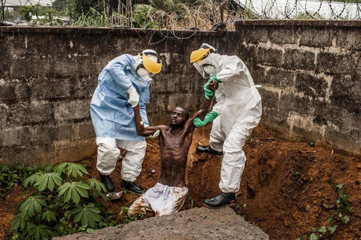 Peter Muller, de EEUU,  ha ganado en la categoría de noticias generales. En la imagen, sanitarios con un paciente con delirios provocados por la enfermedad, en  Hastings (Sierra Leona), el pasado noviembre.