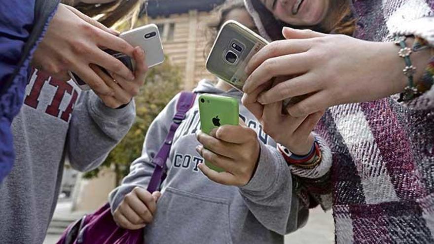 Alumnas de Secundaria utilizando el ´smartphone´ a la salida del instituto.