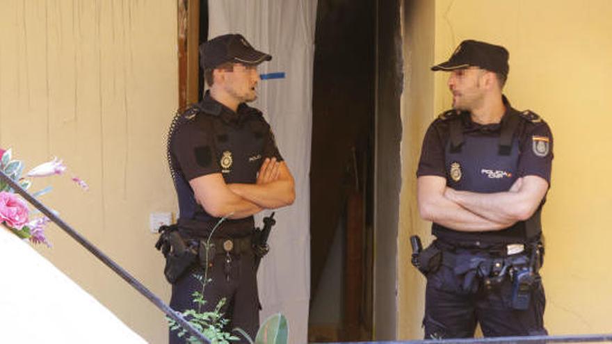 Dos agentes en la casa del parricida.