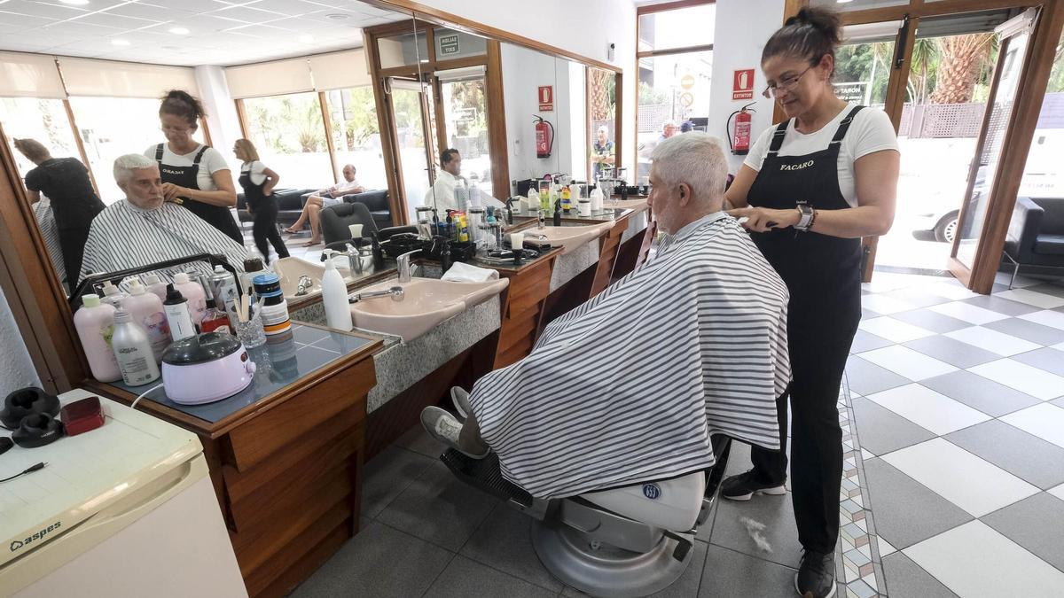 Una peluquera atiende a un cliente en un negocio de Las Palmas de Gran Canaria.