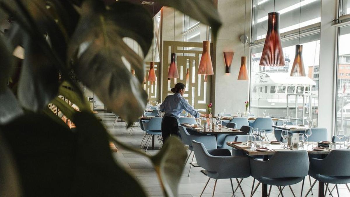 Un camarero prepara una mesa de un restaurante.