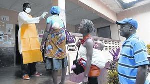 Un enfermero toma la temperatura a varias personas en el condado de Bomi, en Liberia.