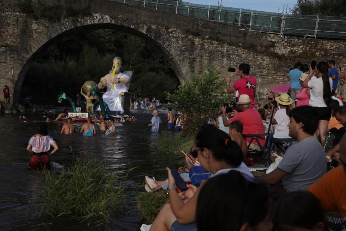 Una embarcación surcando el río Nalón con turistas en la ribera. | Juan Plaza