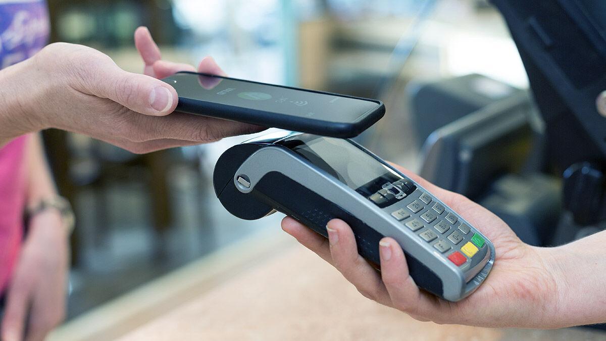 Un usuario pagando una compra con su móvil, algo que será cada vez más habitual tras el lanzamiento de Bizum Pay a finales de mayo de 2026