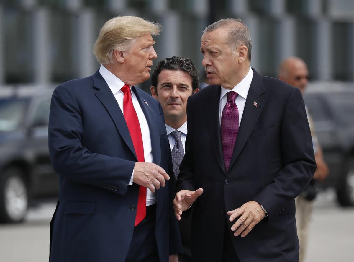 FILE - In this Wednesday, July 11, 2018, file photo, President Donald Trump, left, talks with Turkey’s President Recep Tayyip Erdogan, as they arrive together for a family photo at a summit of heads of state and government at NATO headquarters in Brussels. The White House says Turkey will soon invade Northern Syria, casting uncertainty on the fate of the Kurdish fighters allied with the U.S. against in a campaign against the Islamic State group. (AP Photo/Pablo Martinez Monsivais, File)