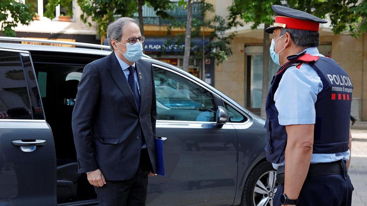 El presidente de la Generalitat, Quim Torra, saludado por un miembro de los Mossos d'Esquadra a su llegada al Ayuntamiento Igualada, este lunes 25 de abril