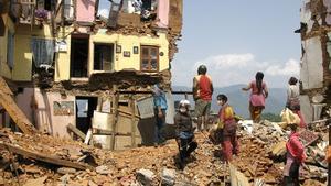  Vecinos de Katmandú buscan entre los escombros de las viviendas derruidas por el terremoto.