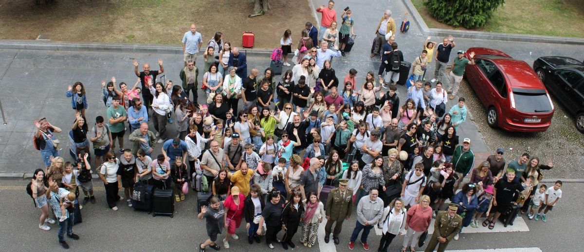 Los niños ucranianos, sus familias de acogida y representantes institucionales posan en la plaza de España de Oviedo. | JER OSPINA