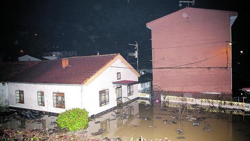 Una parte del barrio de San Vicente, en El Entrego, anegado de agua, ayer por la noche.