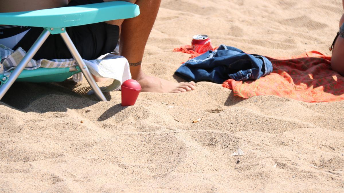 Un banyista conserva i utilitza el con per fumar a la platja tot i ser coneixedor de la nova normativa