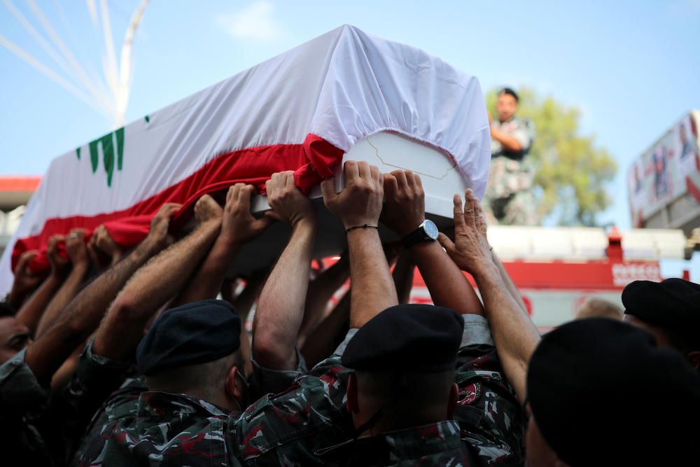 Firefighters carry the coffin of their colleague ...