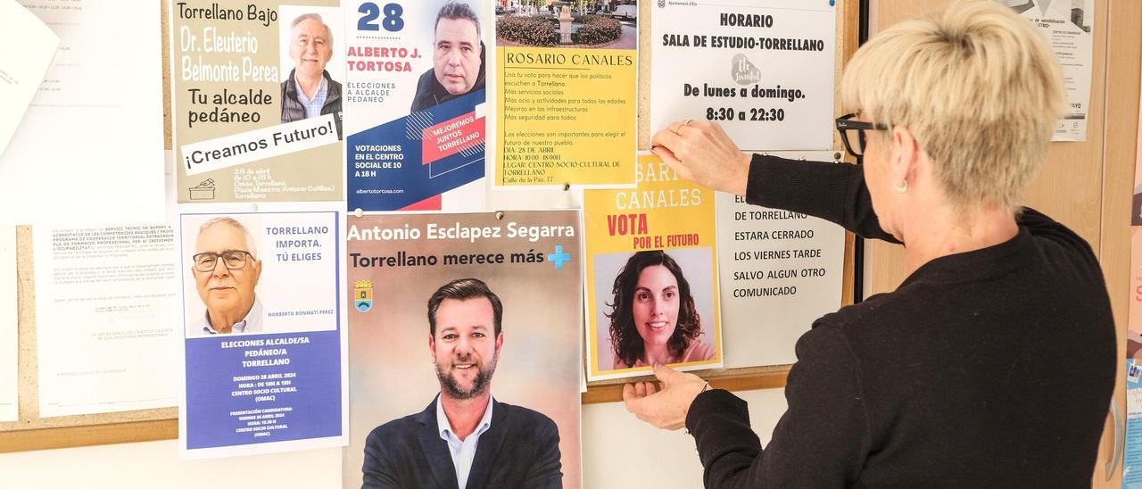 Carteles electorales con algunos candidatos a alcalde pedáneo en Torrellano, en un tablón del centro social.  | ÁXEL ÁLVAREZ