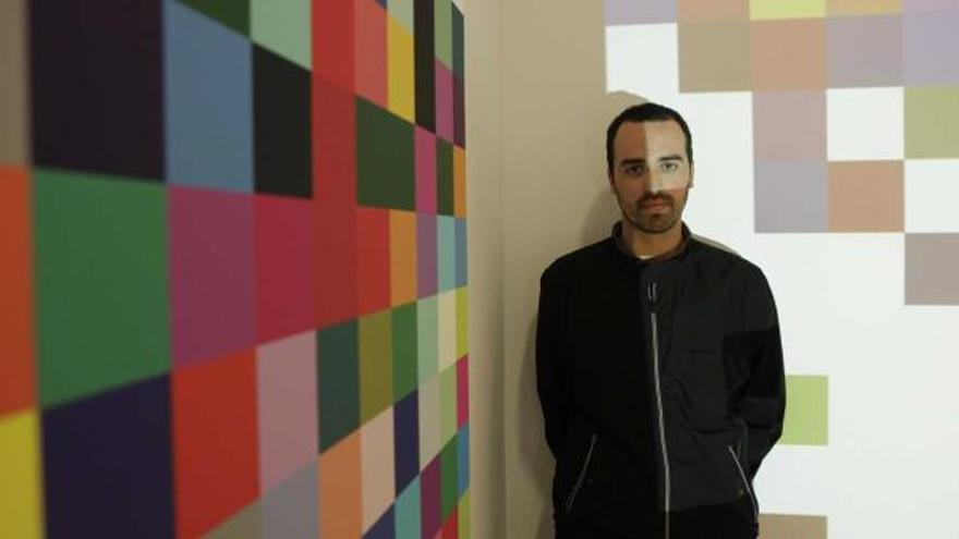 Manuel Fernández, ayer, con el primer lienzo de «Two hundred and sixteen colors», a su derecha, y, a su espalda, la videoproyección con la obra en marcha.