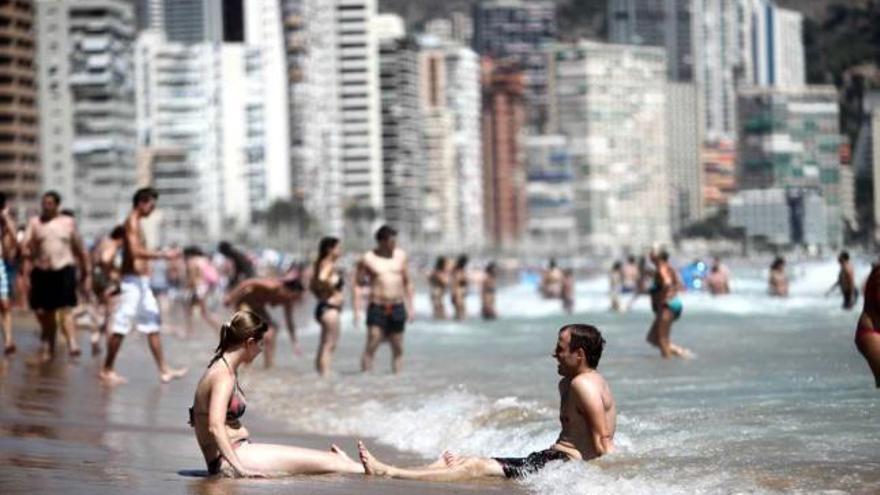 Varias personas aliviándose del intenso calor con un baño en la playa en Benidorm.