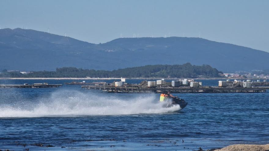 Una moto acuática circulando a gran velocidad entre la costa y las bateas, en A Illa.