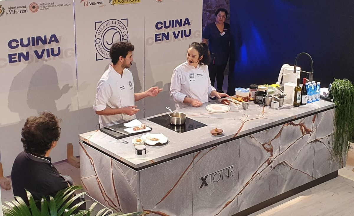 Emmanuel Carlucci y Alejandra Herrador, observados muy de cerca por Pepe Rodríguez, durante su intervención en el &#039;showcooking&#039; de las jornadas gastronómicas de Vila-real.