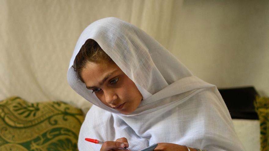 Una nena afganesa absorta en els seus estudis, foto de l’any de la Unicef. | ELISE BLANCHARD / EFE