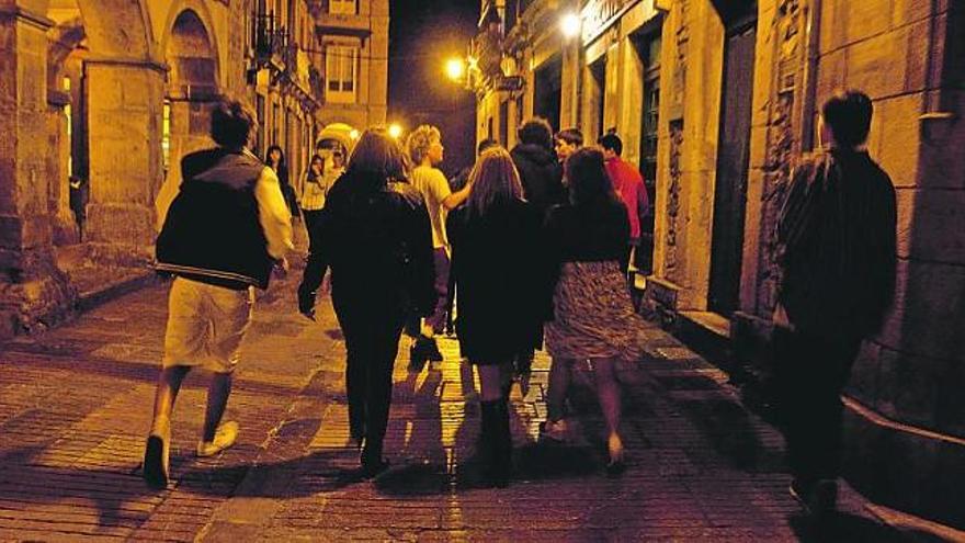 Un grupo de personas camina por la calle de la Ferrería.