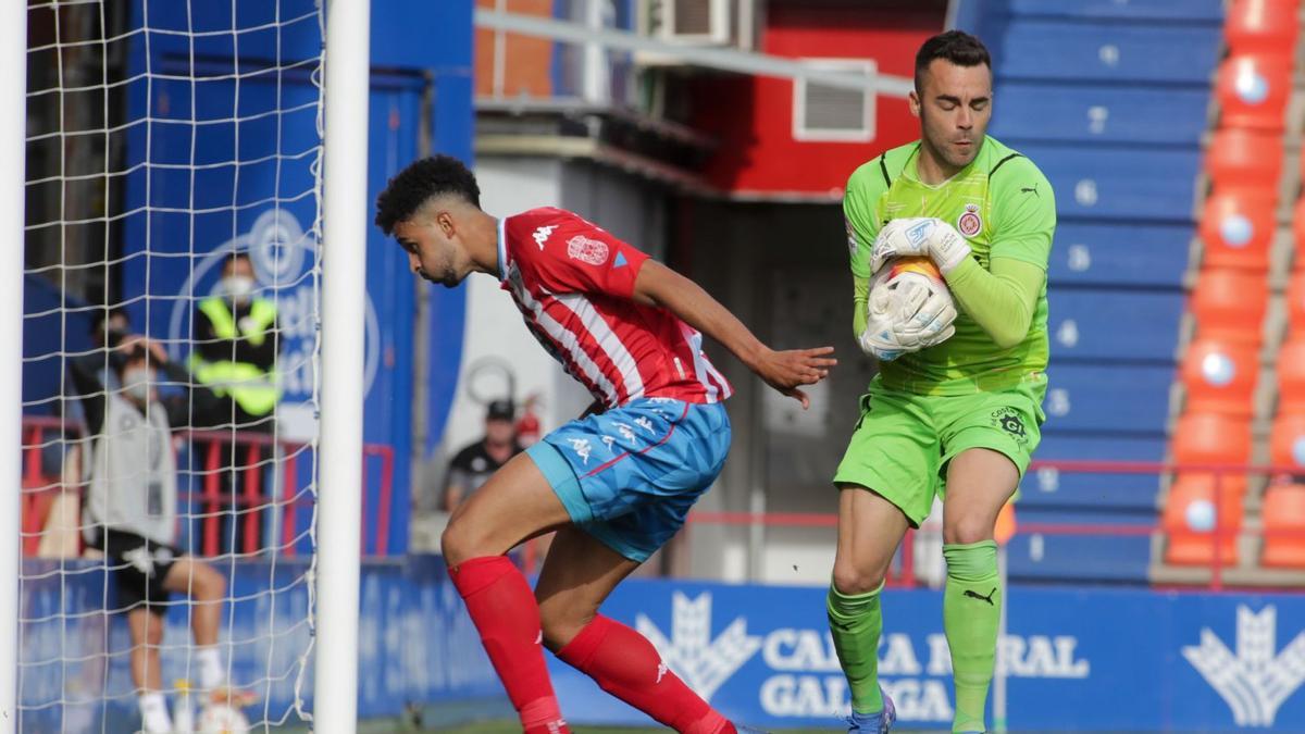 Juan Carlos escopsa una pilota davant Chris Ramos en el partit a l&#039;Anxo Carro contra el Lugo