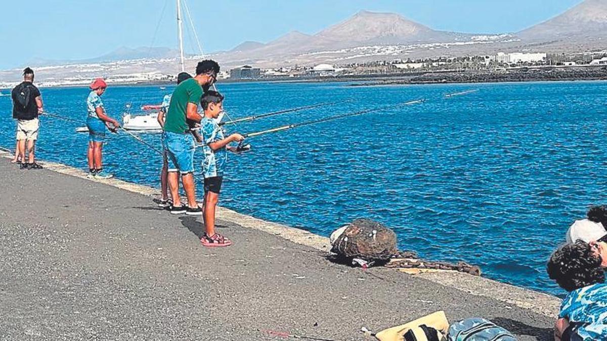 Los participantes en el curso lanzan sus cañas en los muelles de Arrecife.