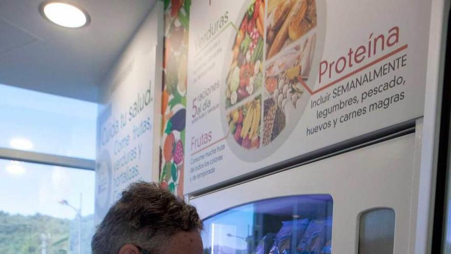 El director de Salud Pública del Nalón saca un producto de la máquina de vending en el espacio saludable.