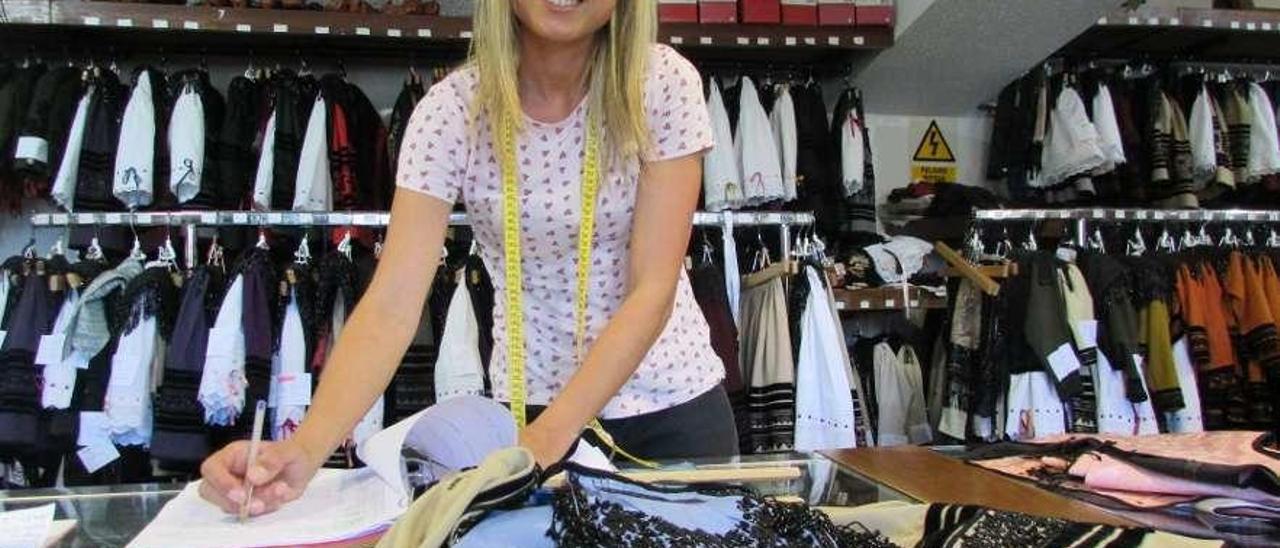 Alba González Sordo, preparando uno de los trajes en la tienda de Tere Sánchez, ayer, en Llanes.