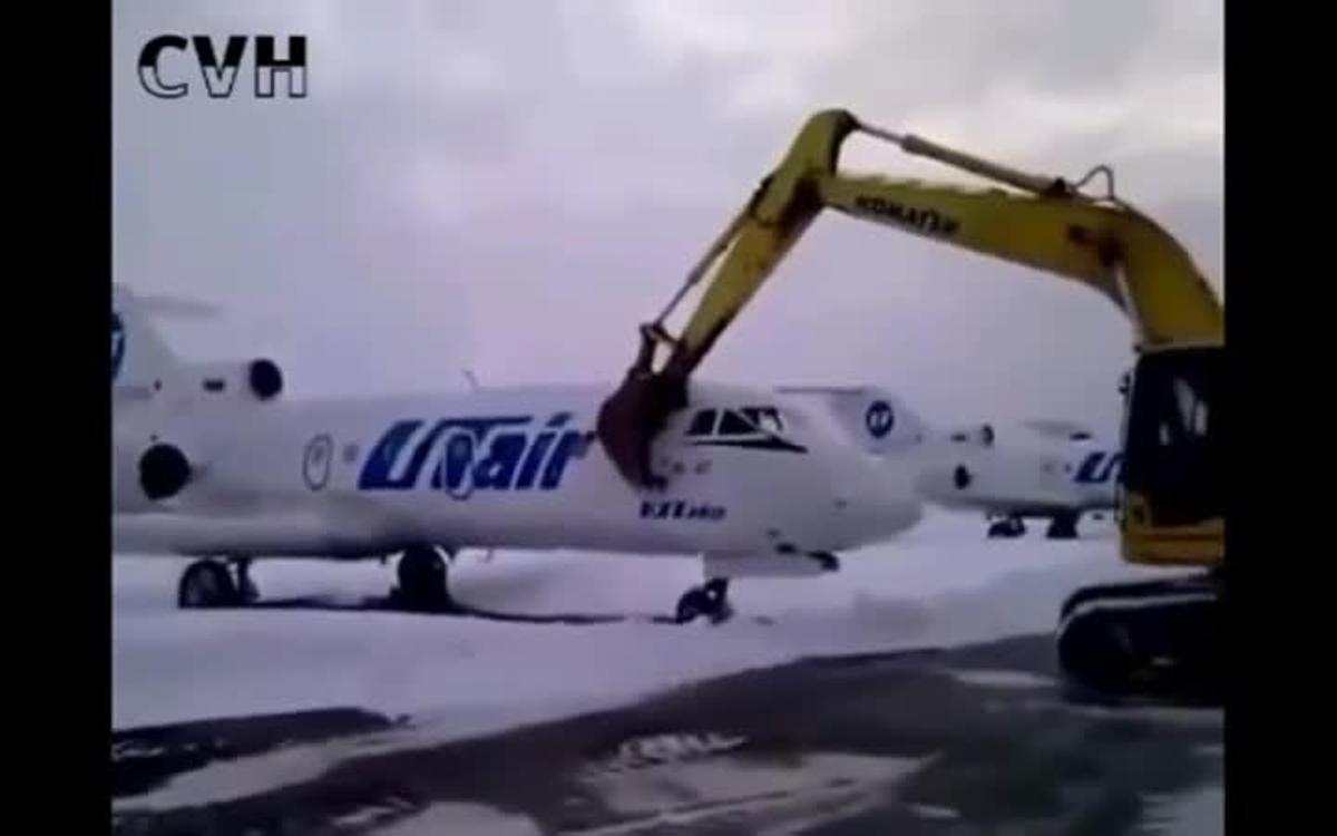 El trabajador despedido destroza el avión con  la excavadora.