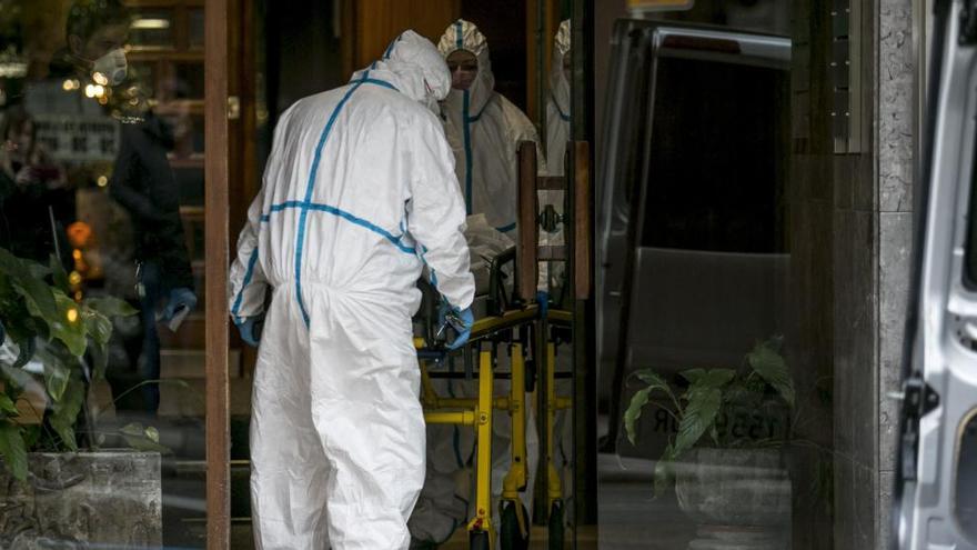 Los forenses retirando el cuerpo del hombre ayer por la tarde.