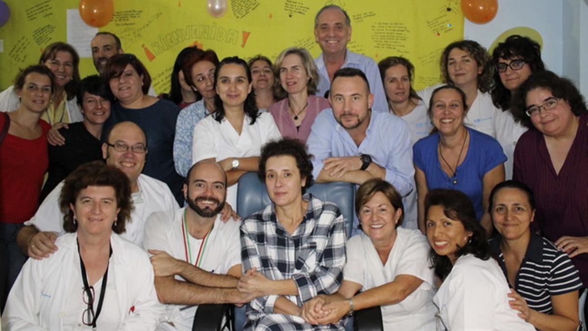 Teresa Romero (en el centro, con una bata de cuadros) y su marido Javier Limón (tras ella, de azul) con parte de los sanitarios que la han estado atendiendo durante los días de aislamiento.