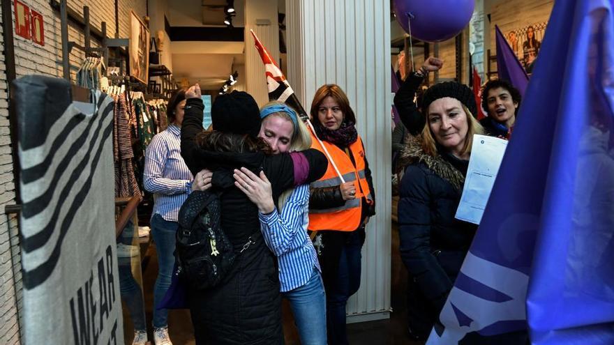 Dos mujeres se abrazan en una tienda de un centro comercial.