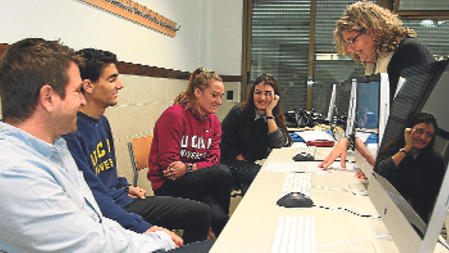 María Miralles, a la derecha, frente a Mireia Belmonte en la UCAM junto a otros estudiantes.