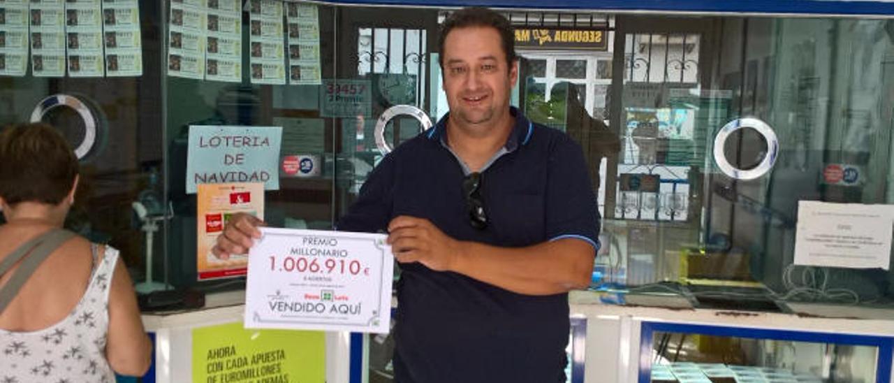 José Carmelo Alonso muestra el cartel con el importe del premio otorgado en La Milagrosa, ayer.